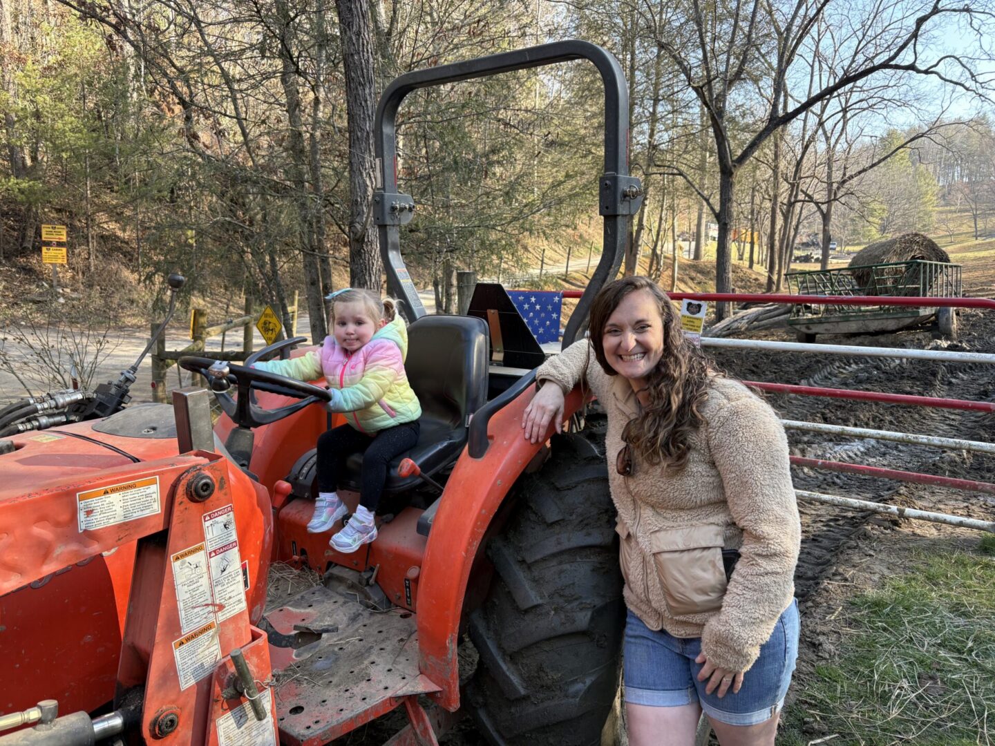 Child and woman with a red tractor.