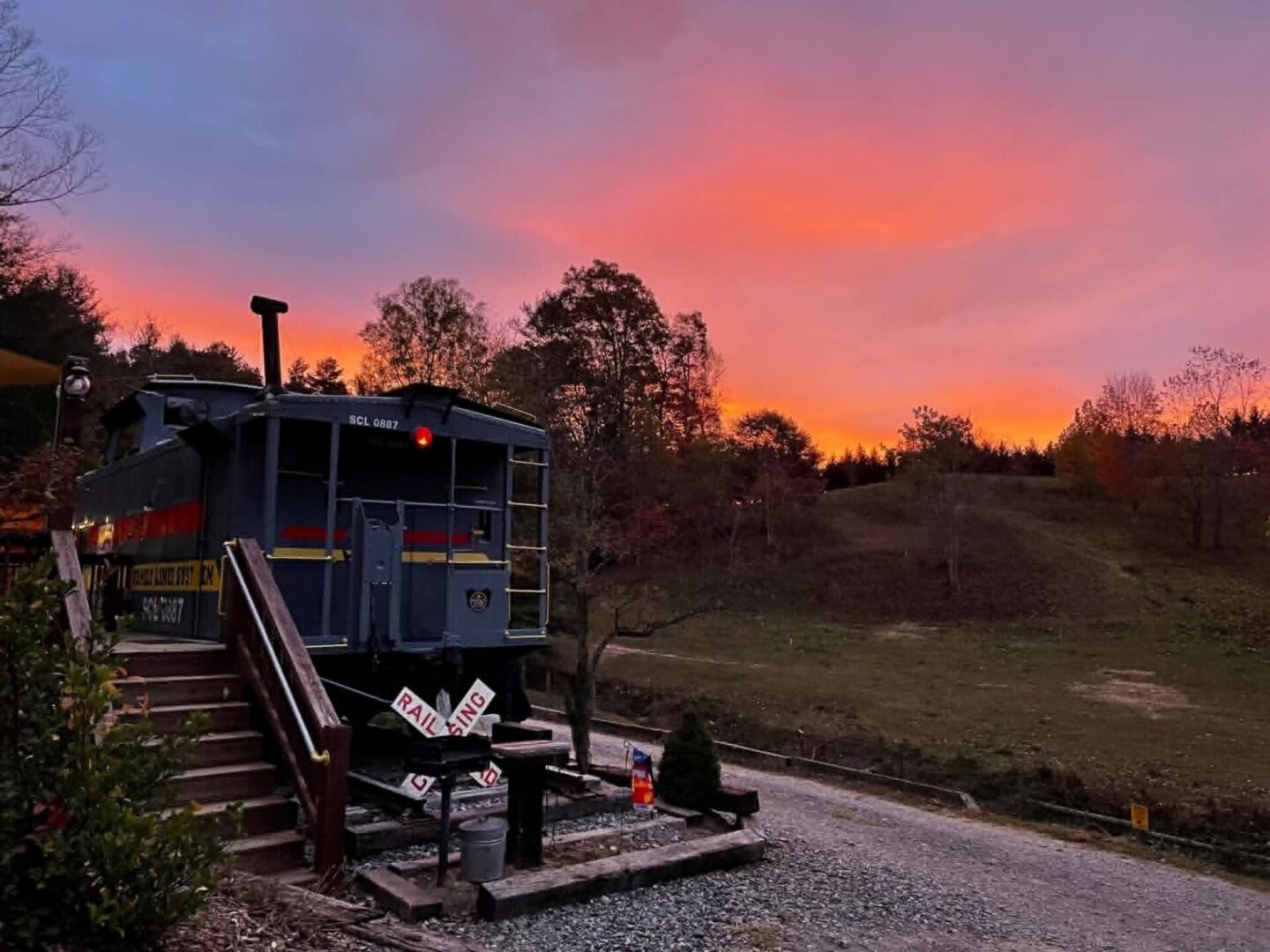 Train caboose at sunset with vibrant sky.