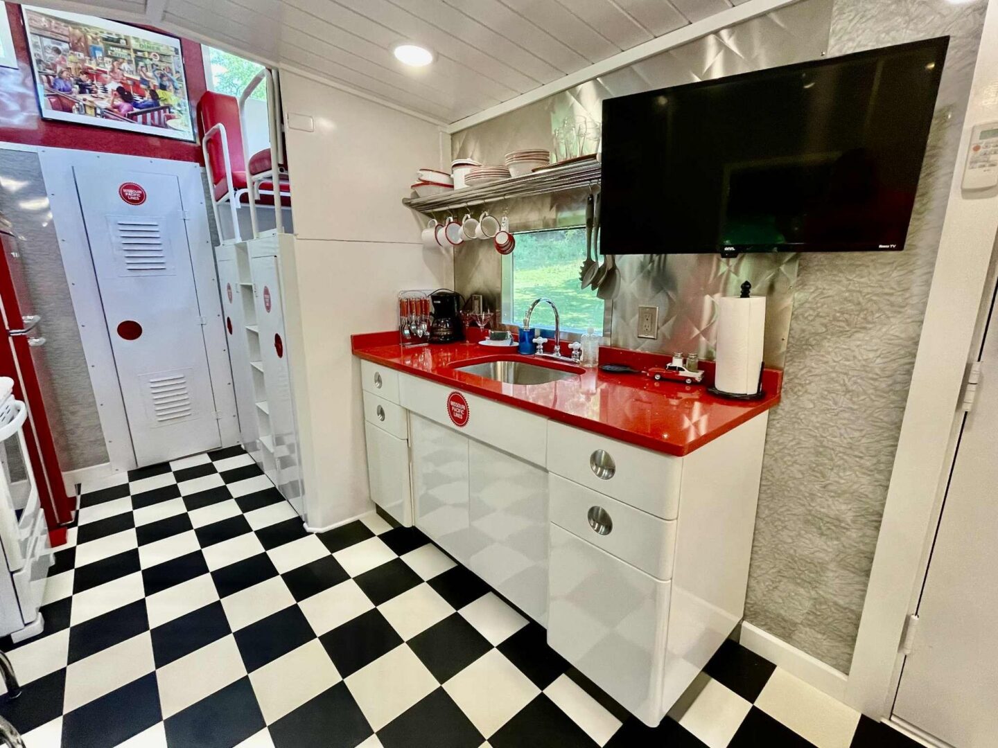 Retro kitchen with red accents and checkered floor.