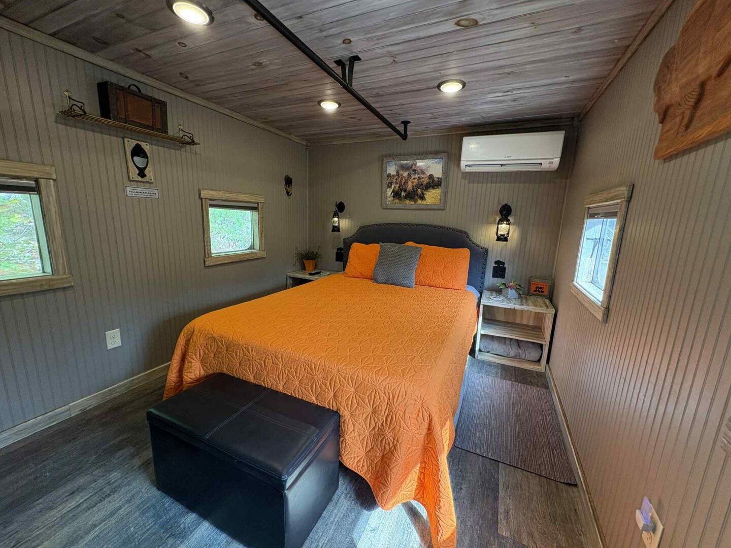 Cozy bedroom with orange bedding and decor.