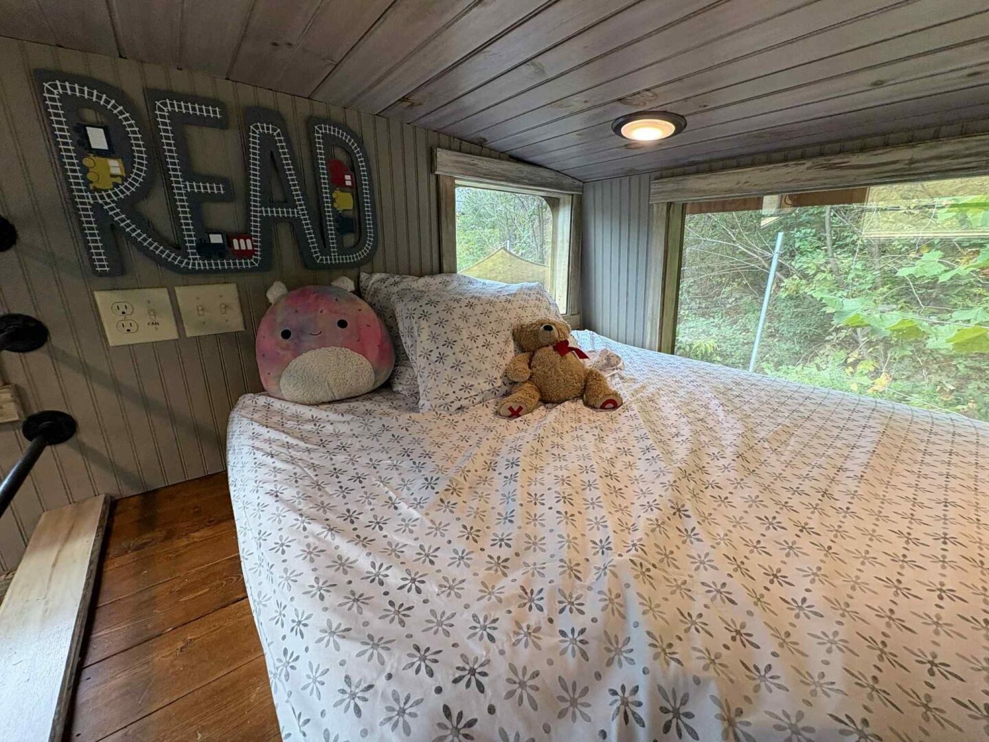 Cozy bedroom with stuffed toys and sign.