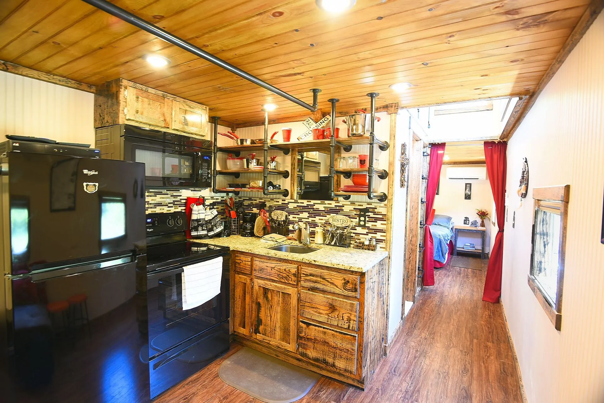 Rustic kitchen with wooden cabinets and shelves.