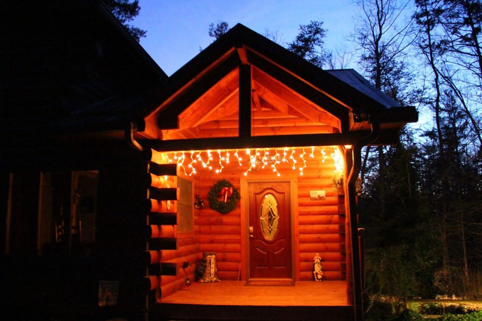 Log cabin entrance with festive lights.