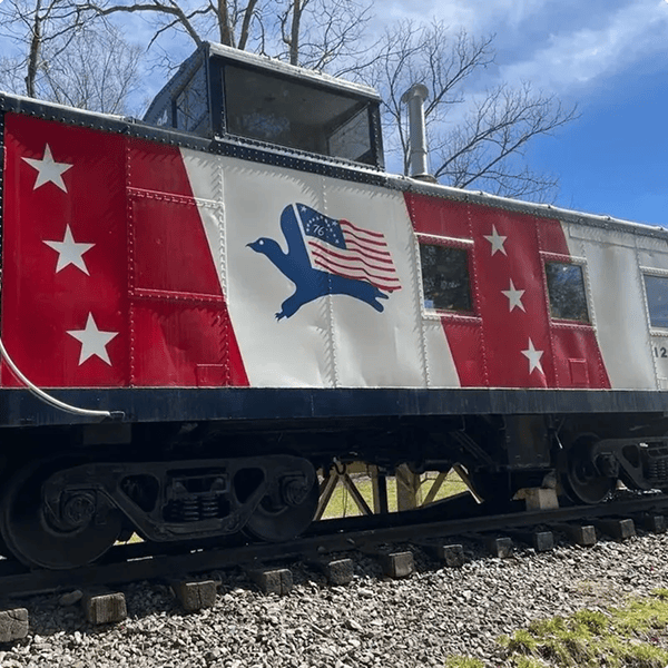 Vintage train car with patriotic flag design.