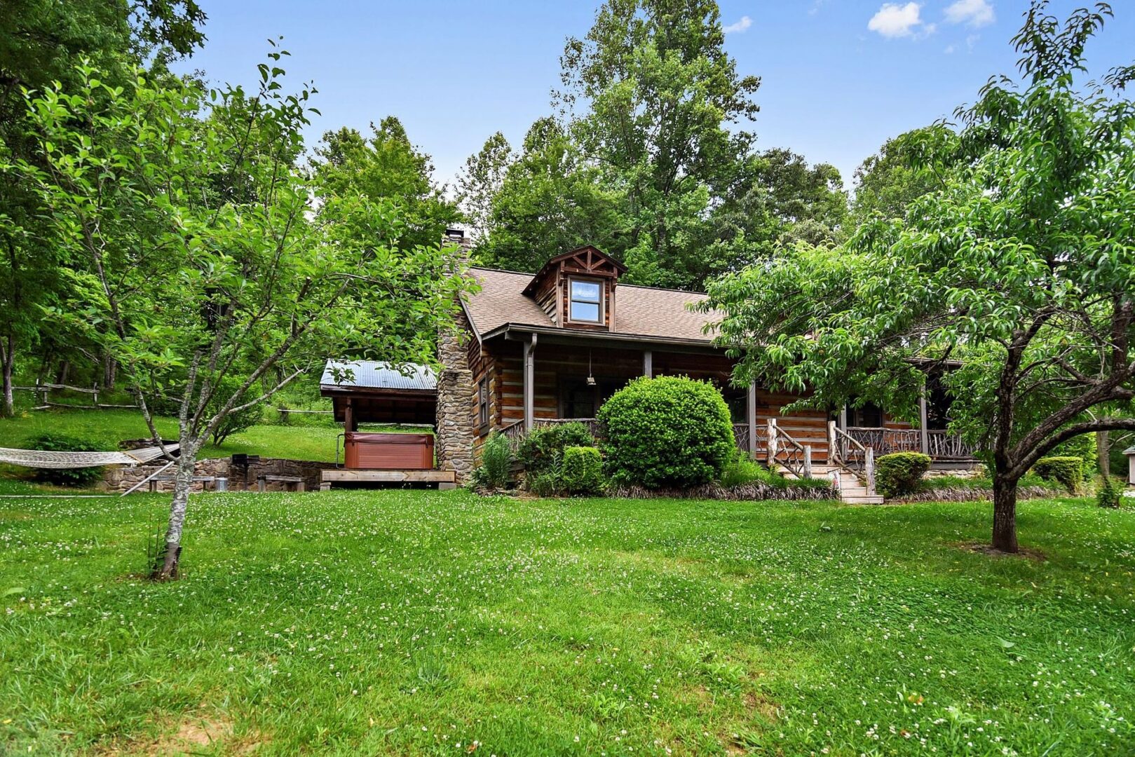 Log cabin surrounded by lush green trees.