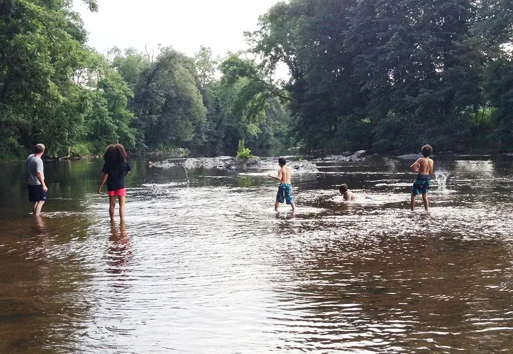 People playing in a shallow river.