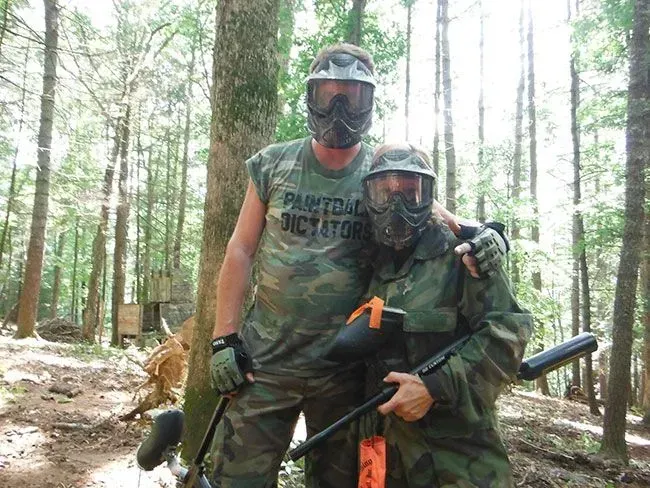 Two people in camouflage paintball gear.