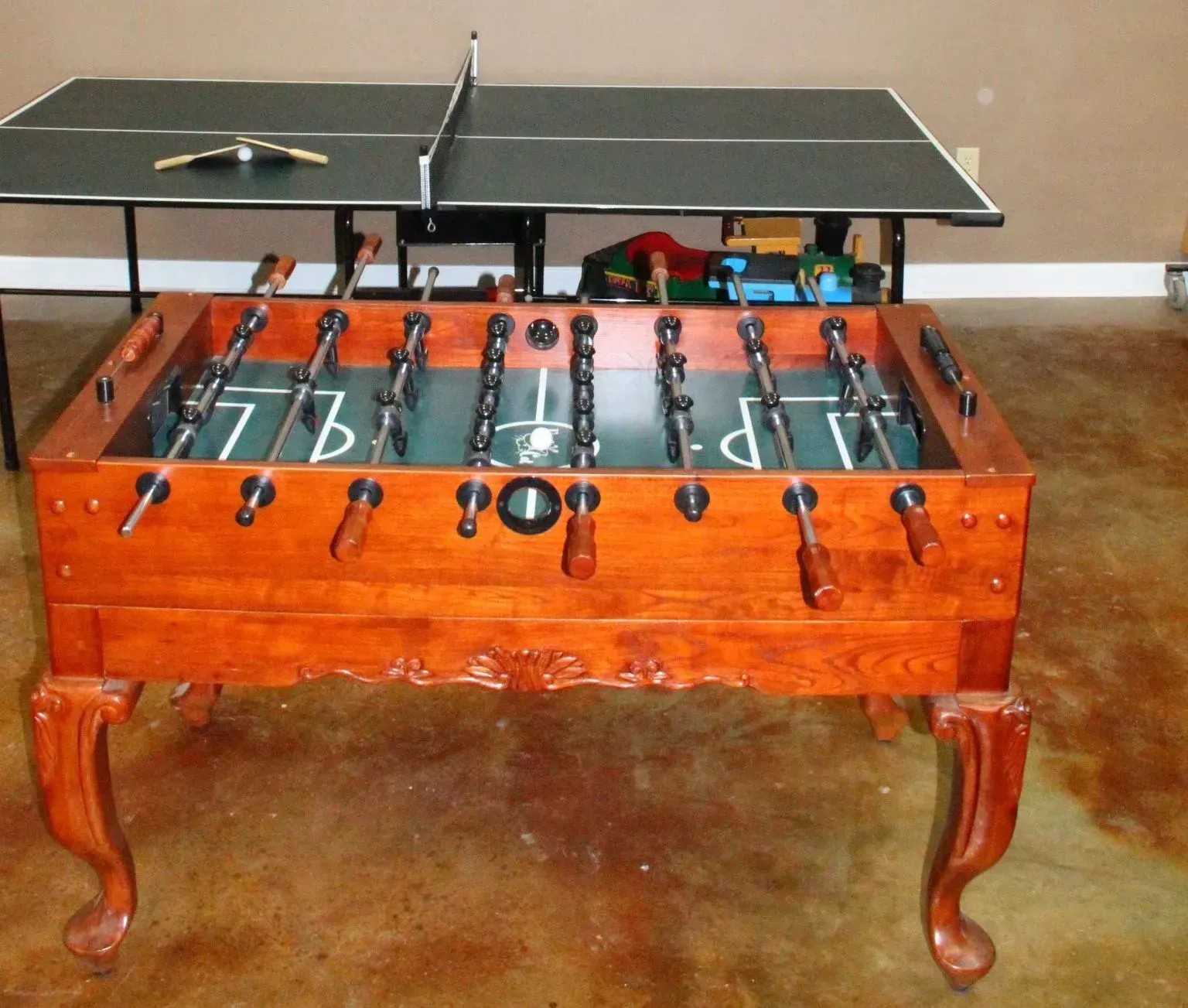 Foosball and ping pong tables in room.