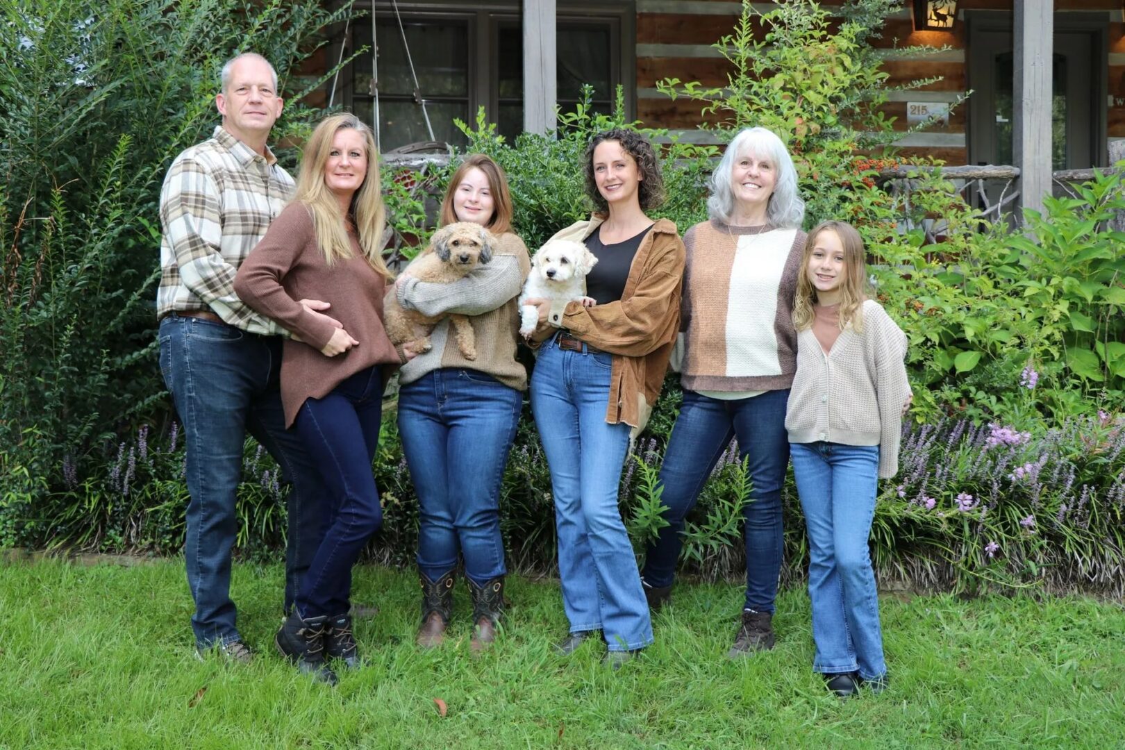 Family posing with dogs in garden.