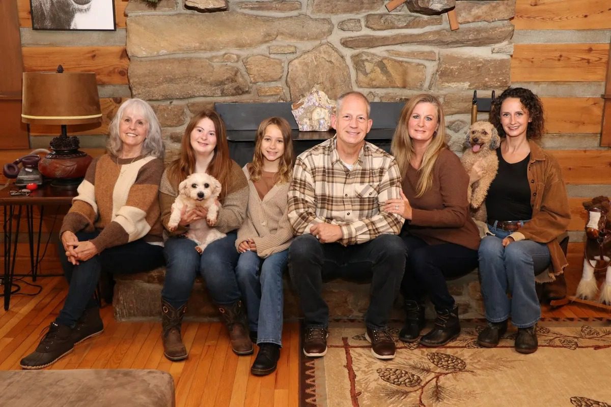 Family and dogs sitting in cozy room.
