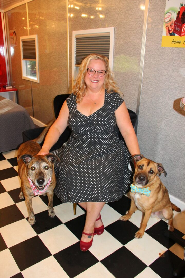 Woman with two dogs on checkered floor.