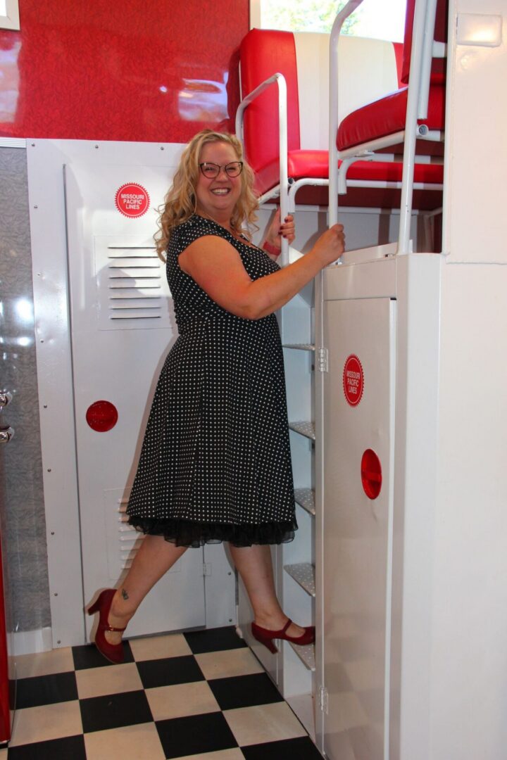 Woman climbing ladder in retro diner setting.