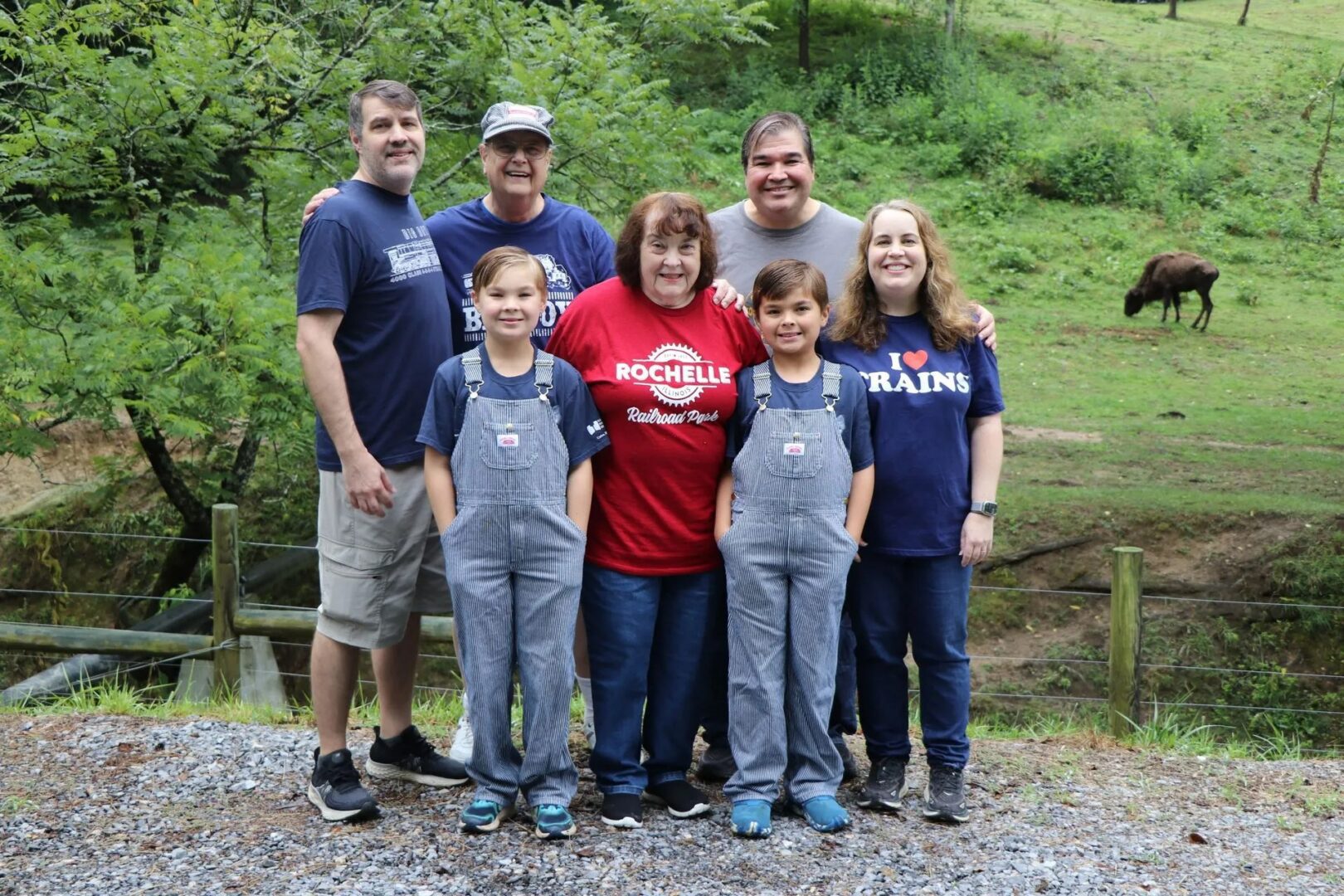 Family posing outdoors with grassy background.