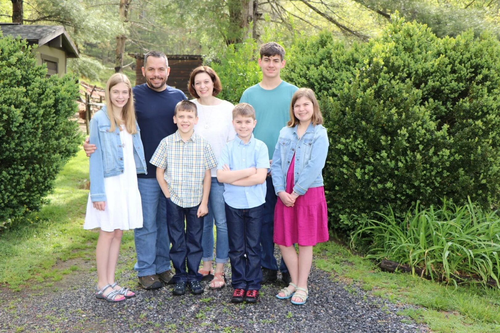Family posing together in a garden setting.