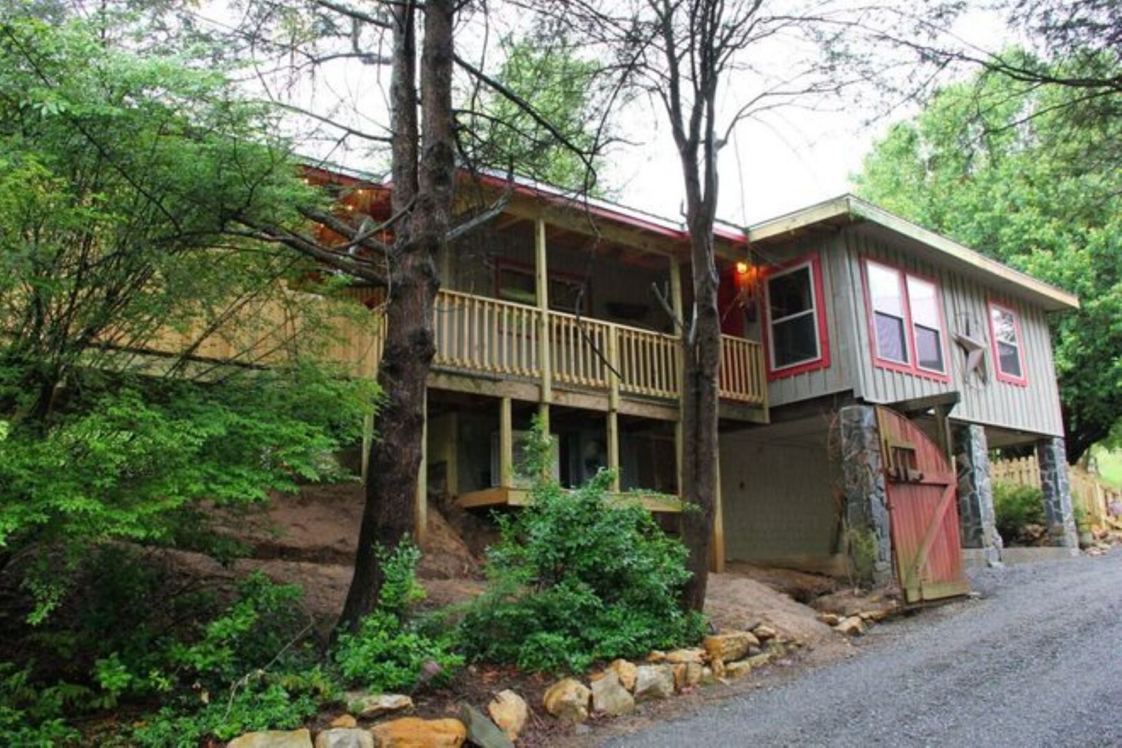 Wooden house surrounded by trees and greenery.
