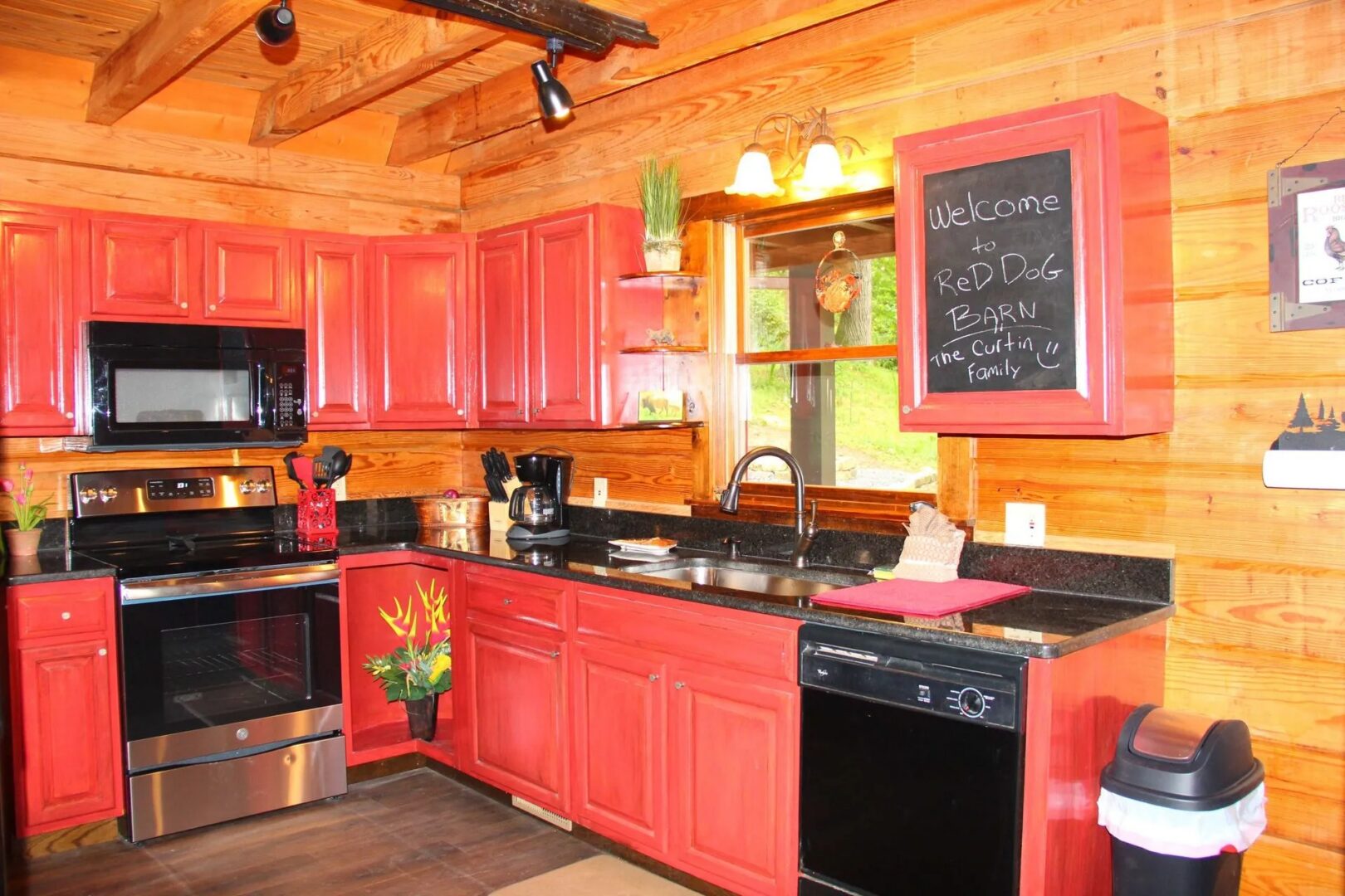 Rustic kitchen with red cabinets and appliances.