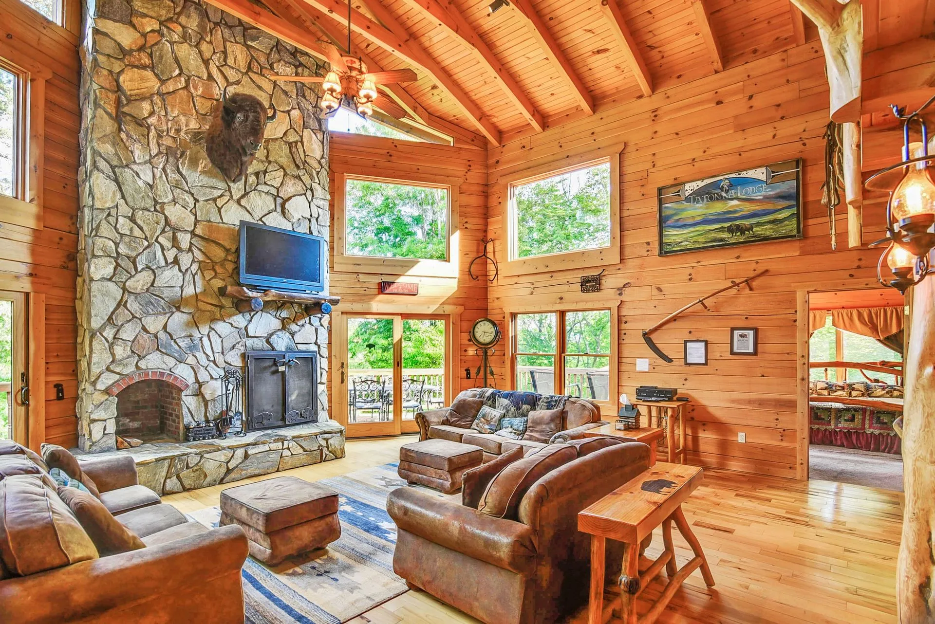 Rustic living room with stone fireplace, wood interior.