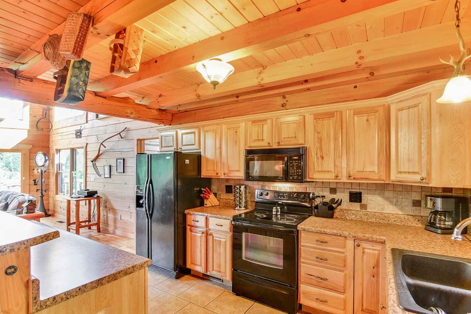 Rustic kitchen with wooden cabinets and beams.