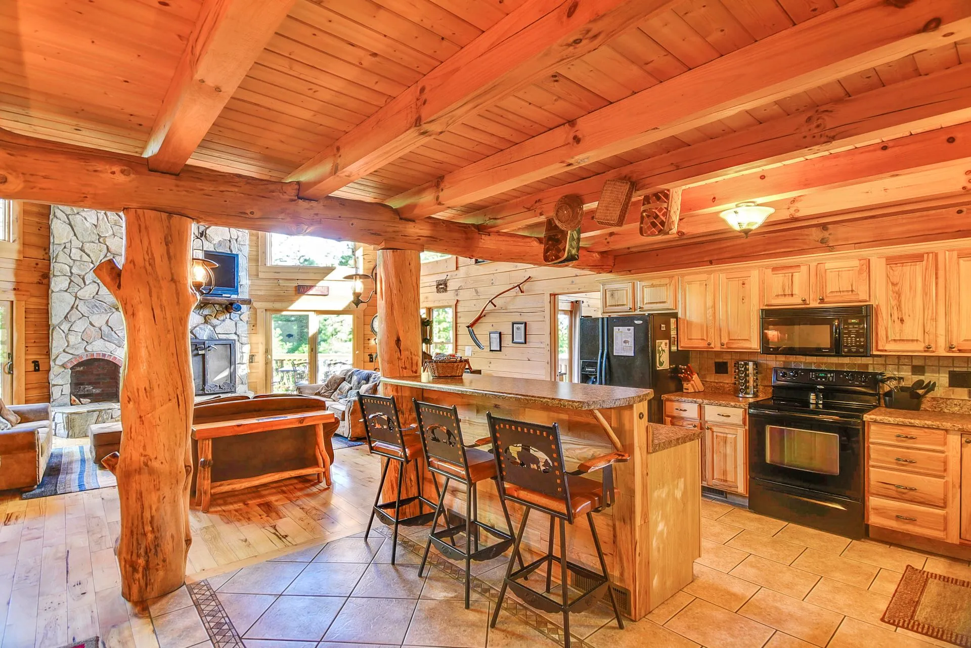 Rustic wooden kitchen with stone fireplace.