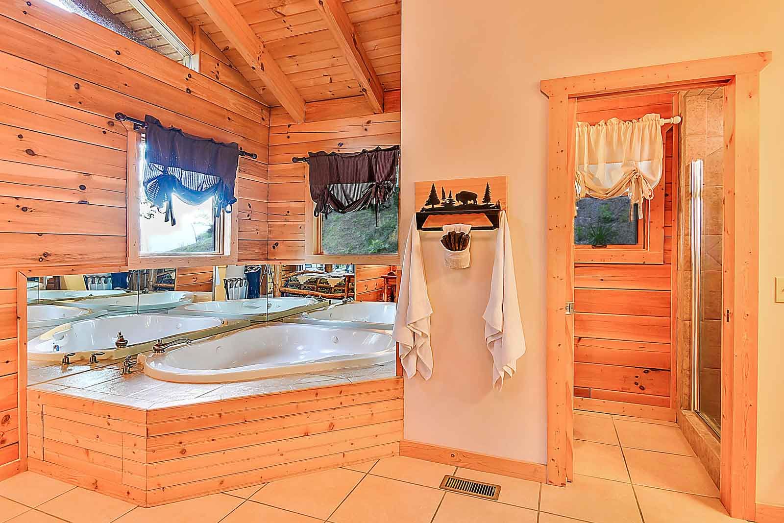 Wooden bathroom with corner bathtub and towels.