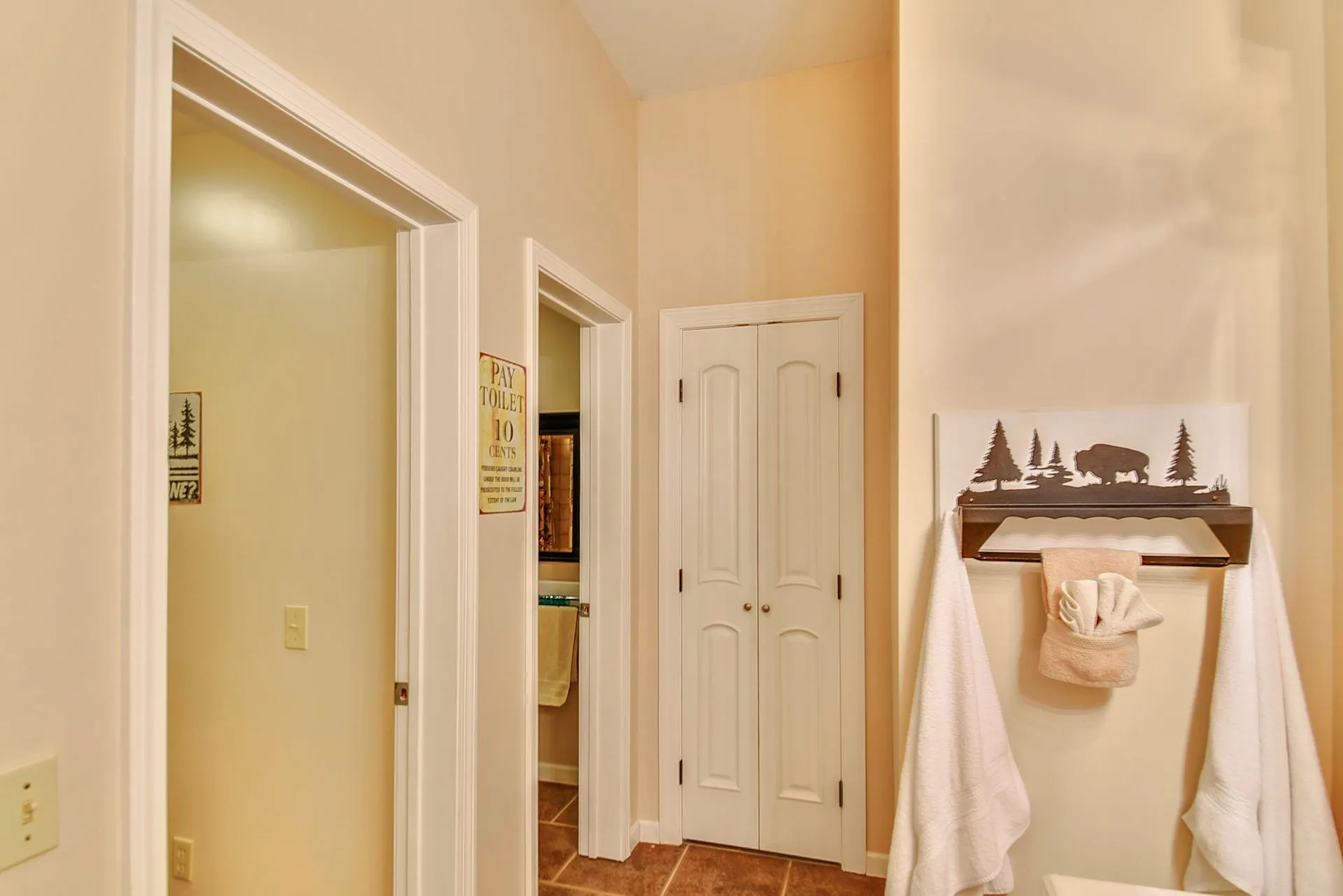 Bathroom hallway with towels and decorative sign.