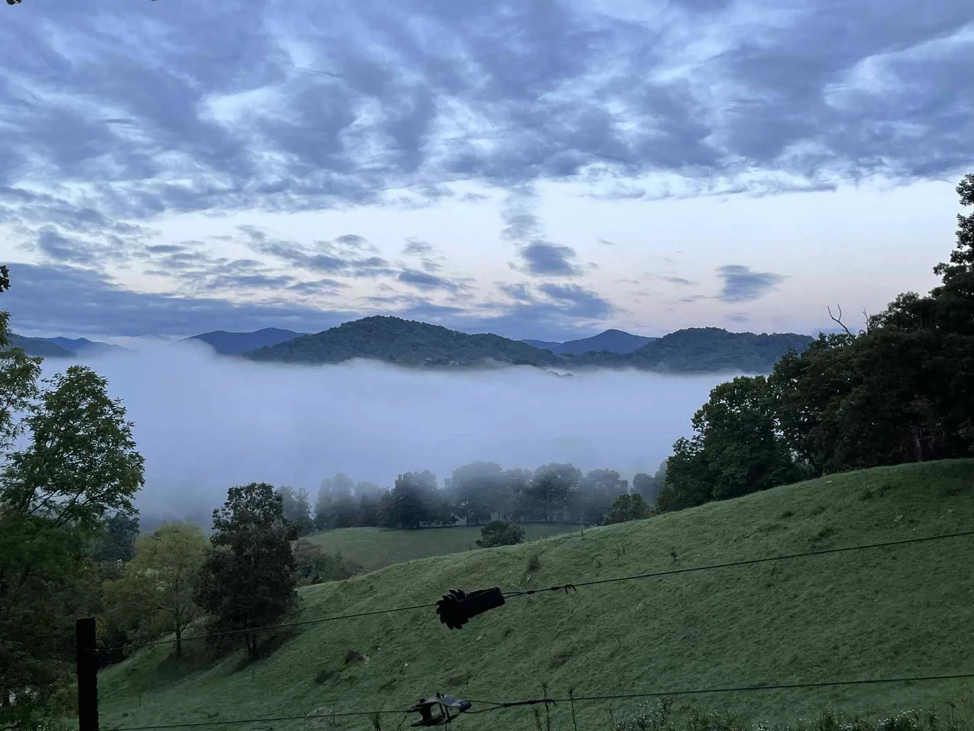 Foggy mountain landscape with green hills.