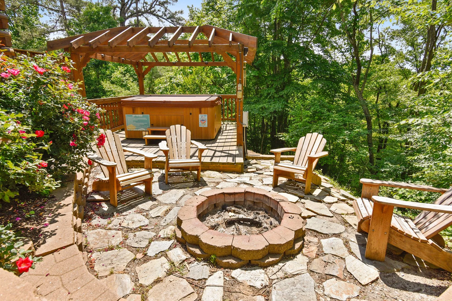 Outdoor fire pit with wooden chairs and pergola.