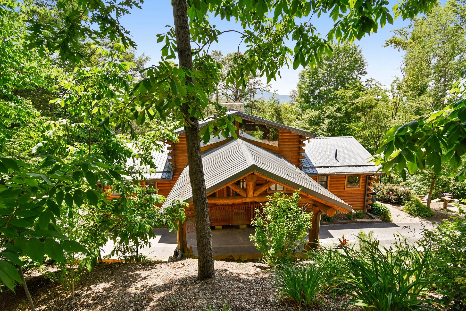 Log cabin surrounded by lush green trees.